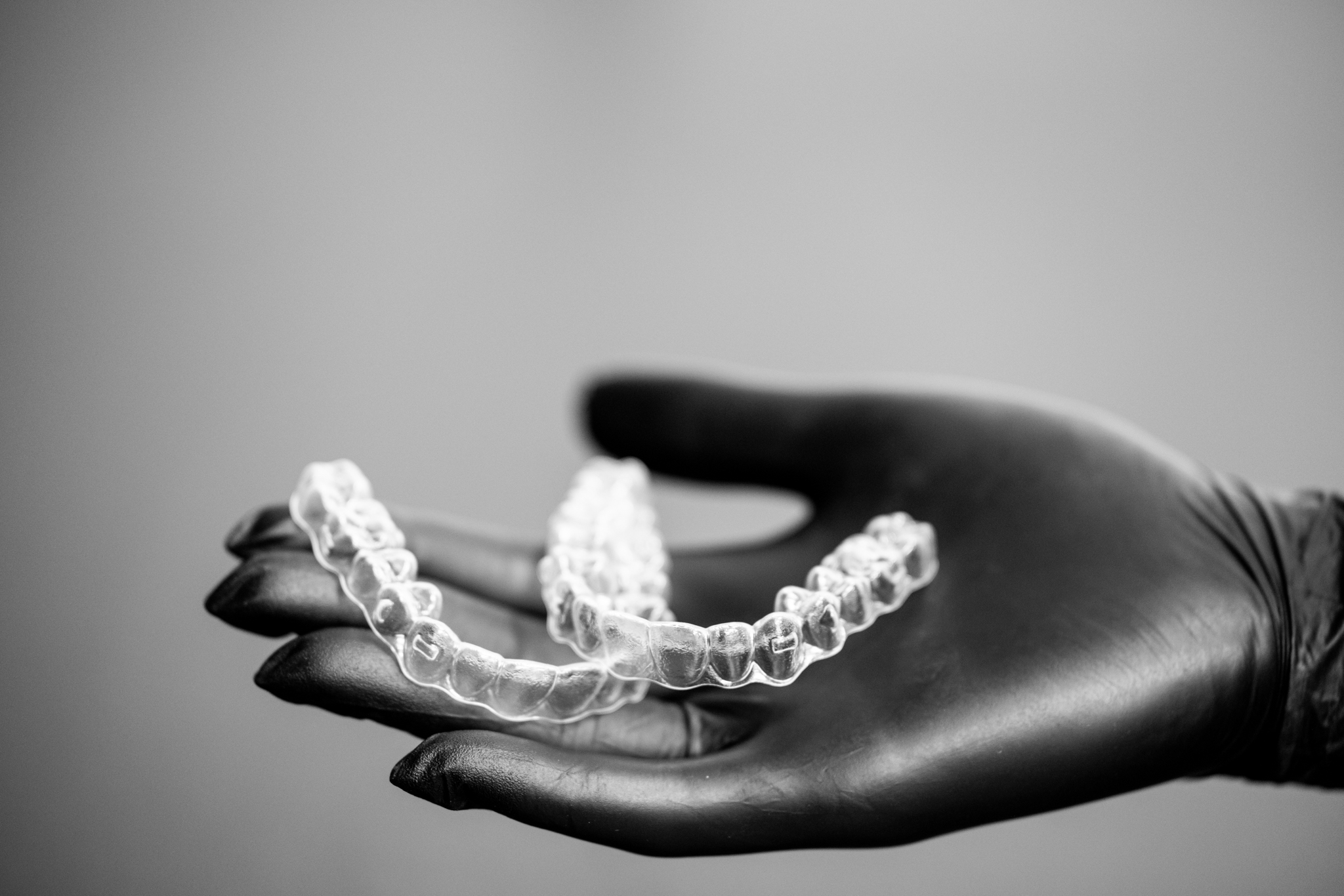 Clear orthodontic aligners on dentist hand modern invisible braces